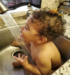 baby playing in a kitchen sink