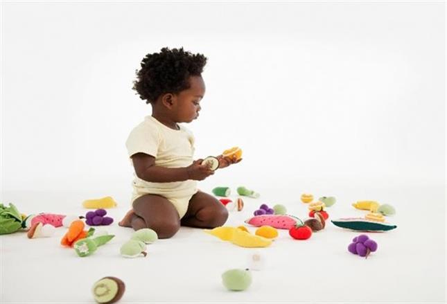 child eating different types of fruit